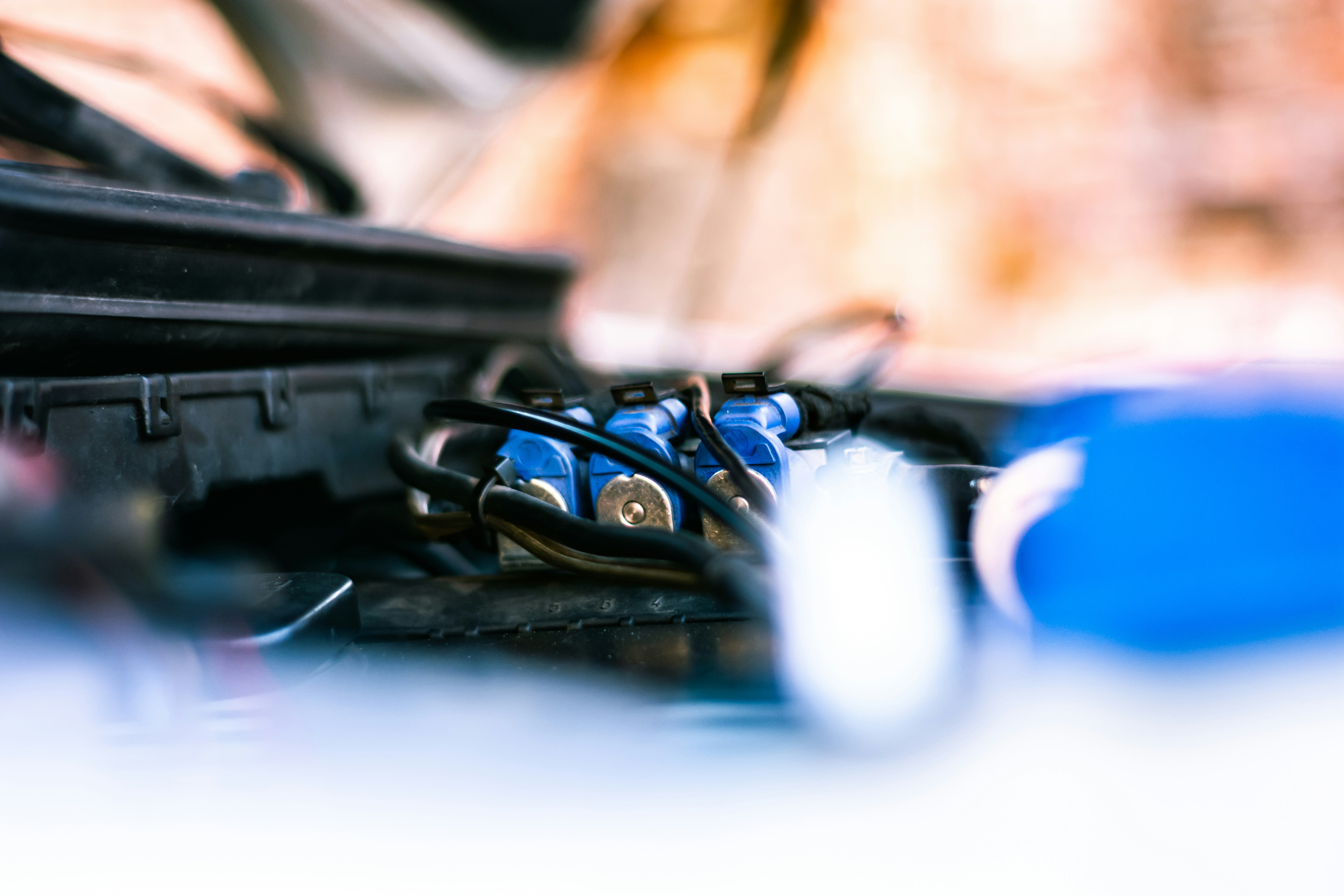 Automotive wiring harness and electrical components on dark background, blue circuit traces glowing