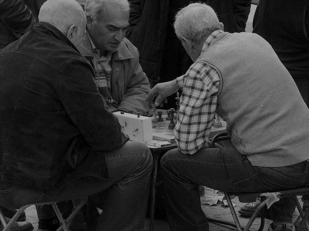 three men playing cheese grayscale photography