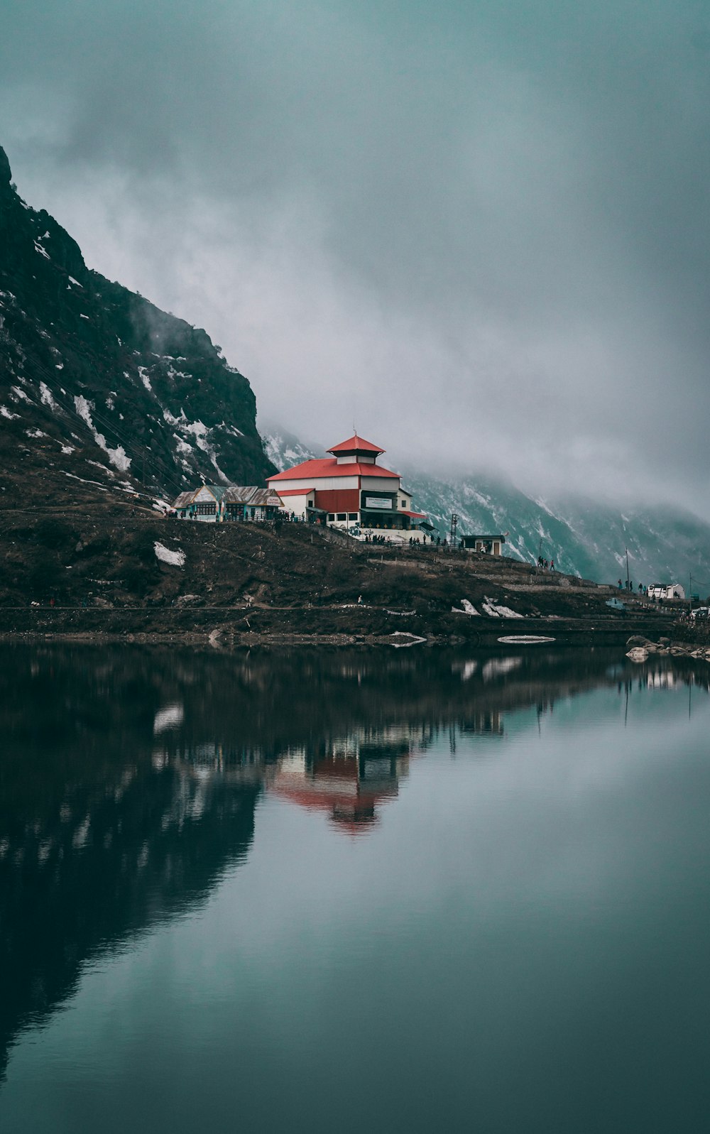 edificio in cemento bianco e rosso vicino allo specchio d'acqua