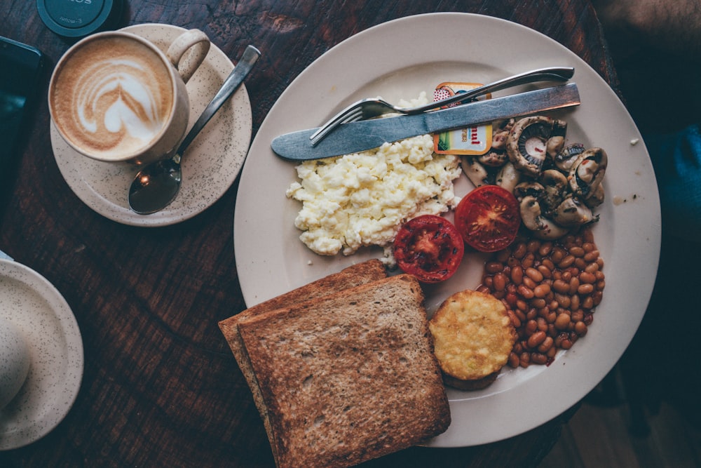 food lot in a white plate near a knife and fork close-up photography