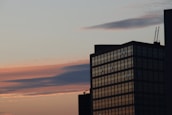 A completed high-rise building showcasing modern architecture against a sunset backdrop.