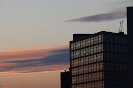 A completed high-rise building showcasing modern architecture against a sunset backdrop.