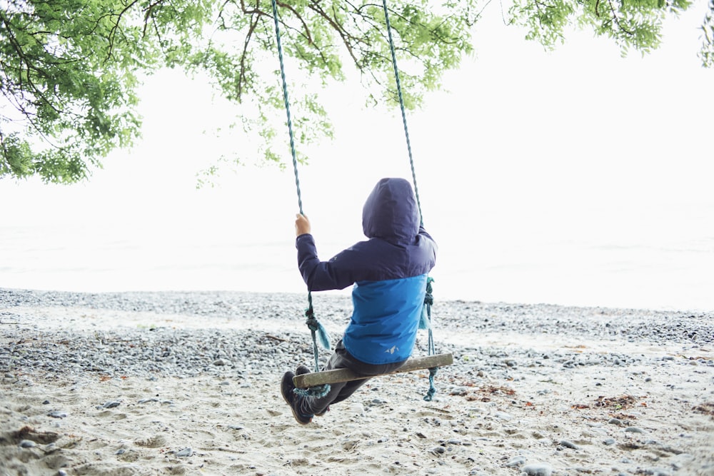 person wearing jacket sitting on swing