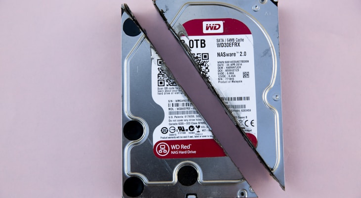 Western Digital WD Red internal HDD sliced in half on pink surface