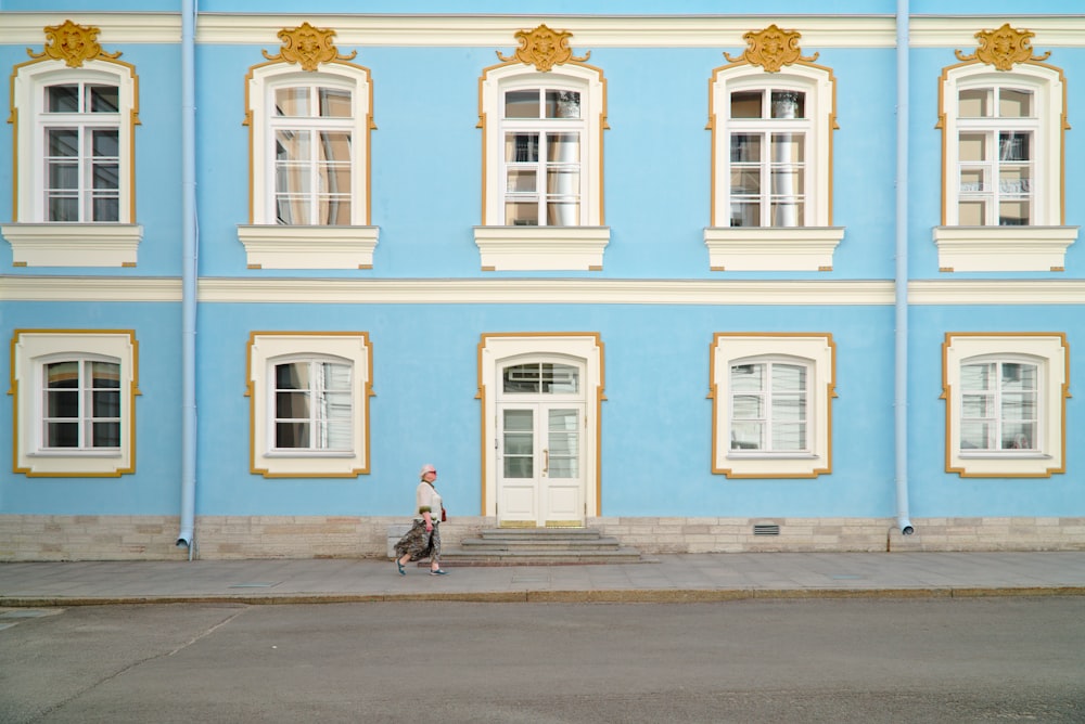 femmes marchant près d’un bâtiment au mur bleu pendant la journée