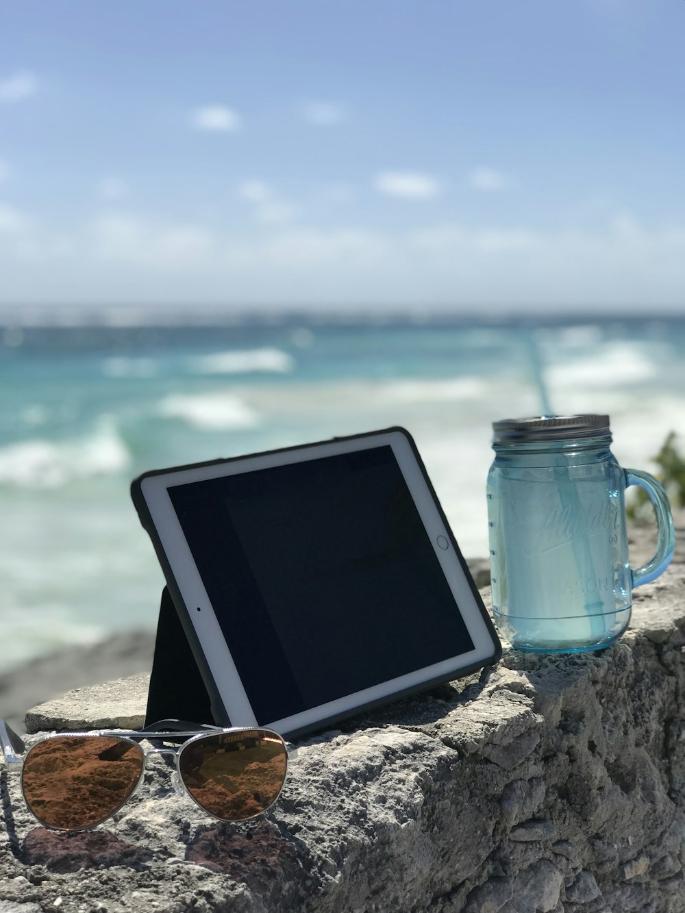 gold iPad beside glass jar