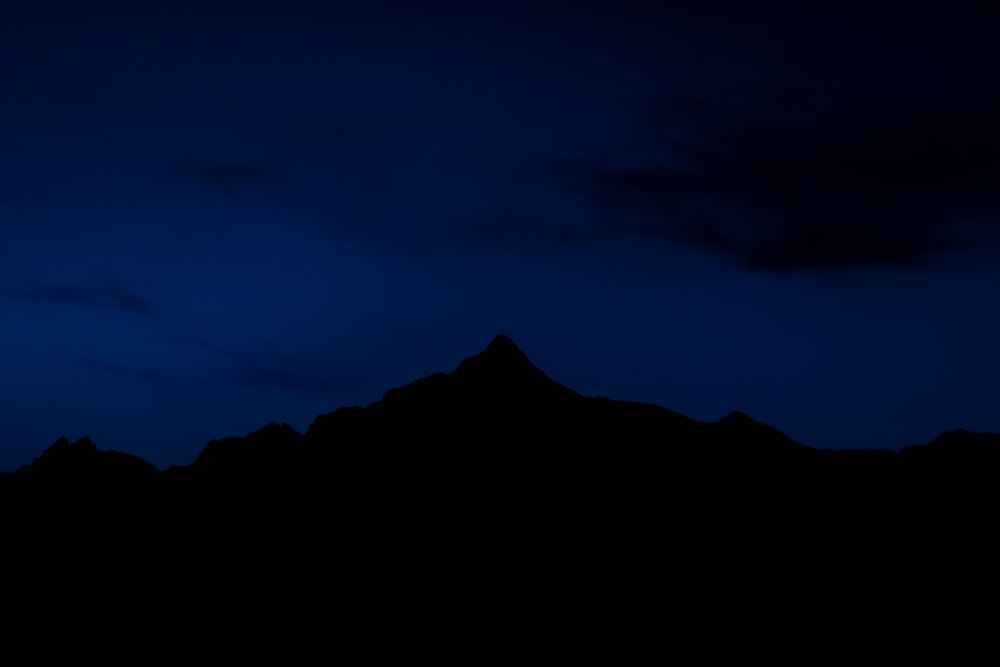 La sagoma di una montagna contro un cielo blu scuro
