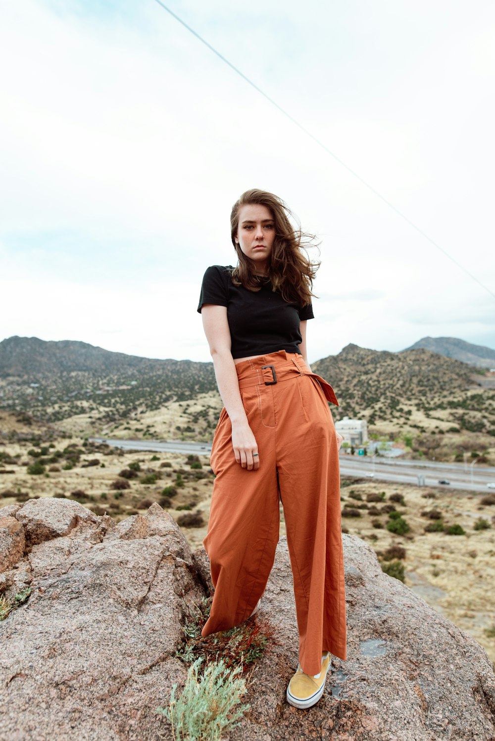 woman standing on big rock looking straight