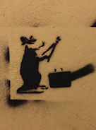A detailed shot of Banksy's rat stencil holding a paintbrush.