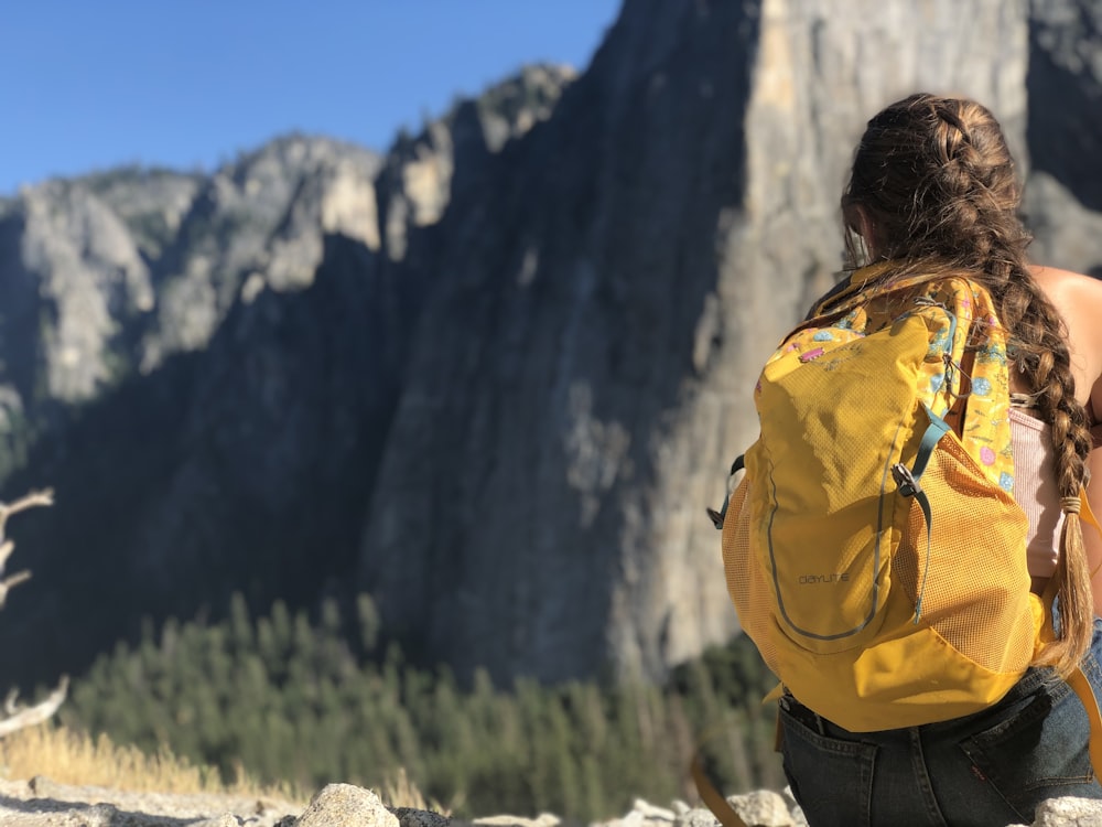 woman with yellow backpack on focus photography
