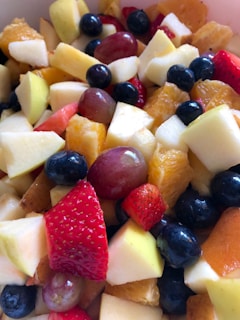 A colorful assortment of fresh fruits including strawberries, blueberries, grapes, apples, and orange slices.