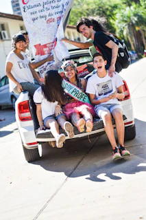 A group of new drivers celebrating their test success outside the driving school office