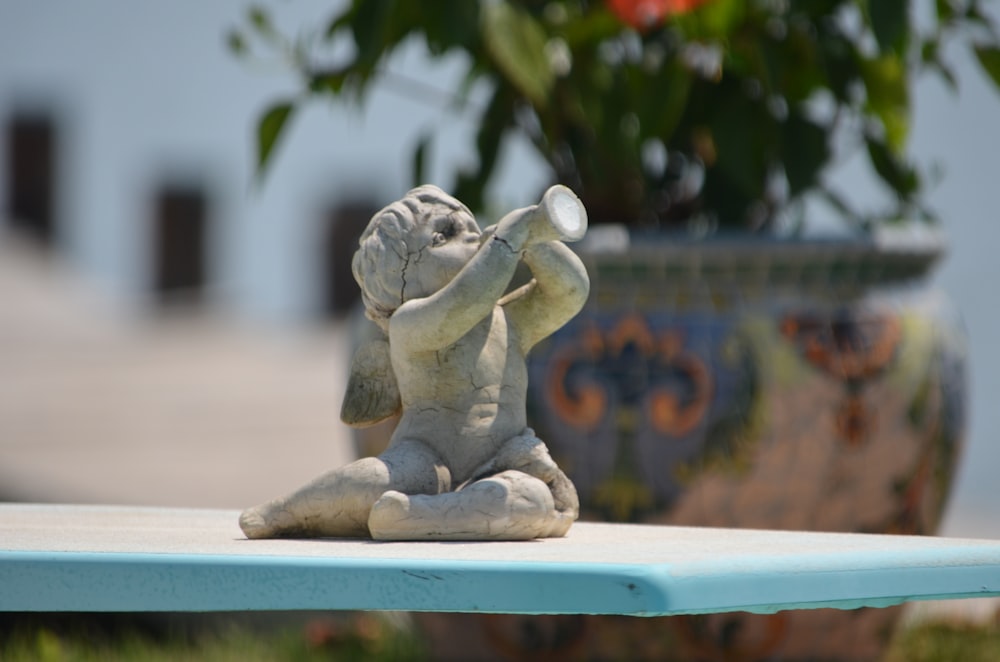 toddler holding cup statuette