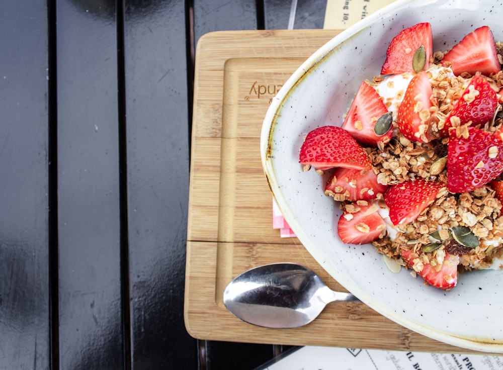 sliced strawberries in white ceramic bowl