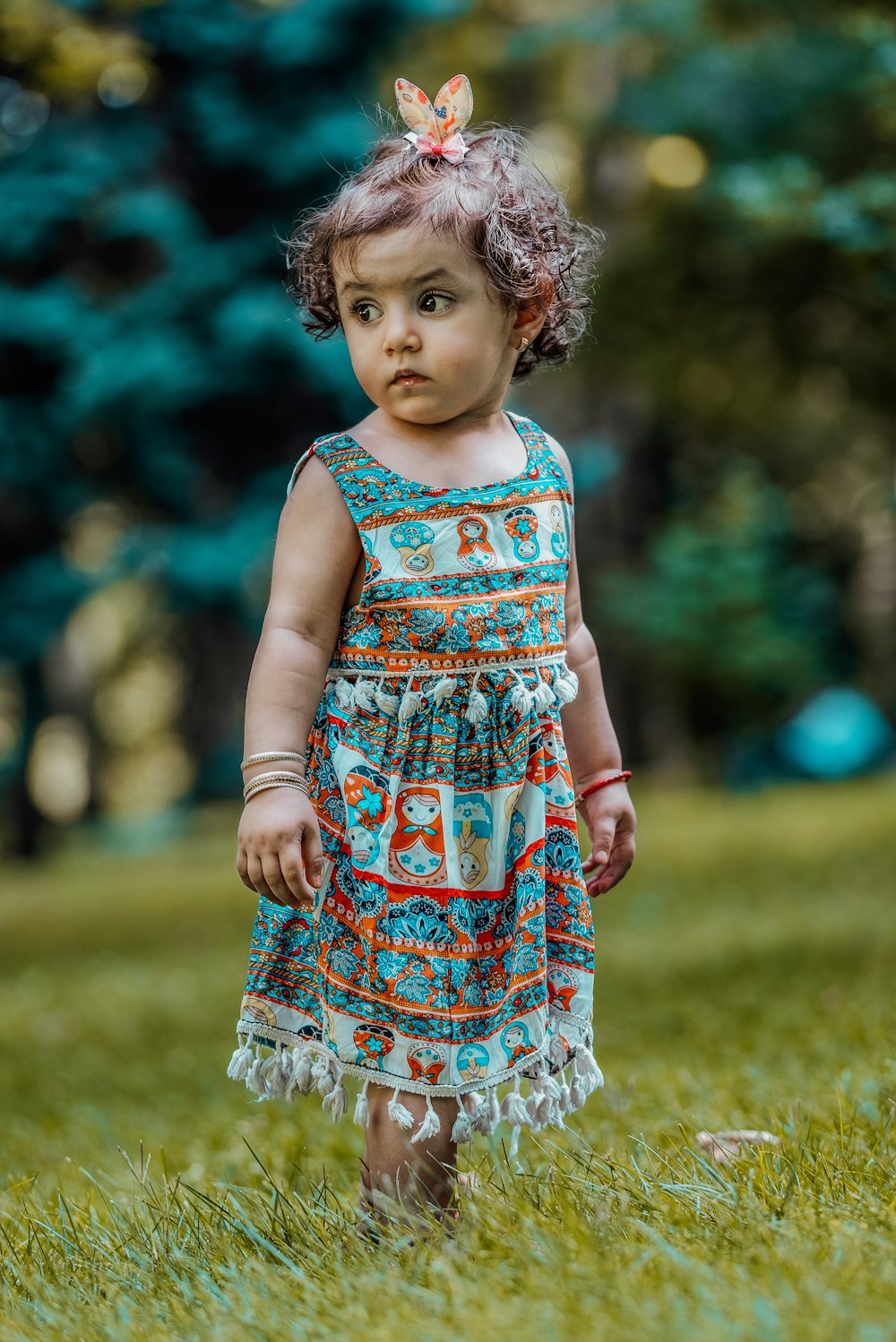 girl wearing dress standing in lawn