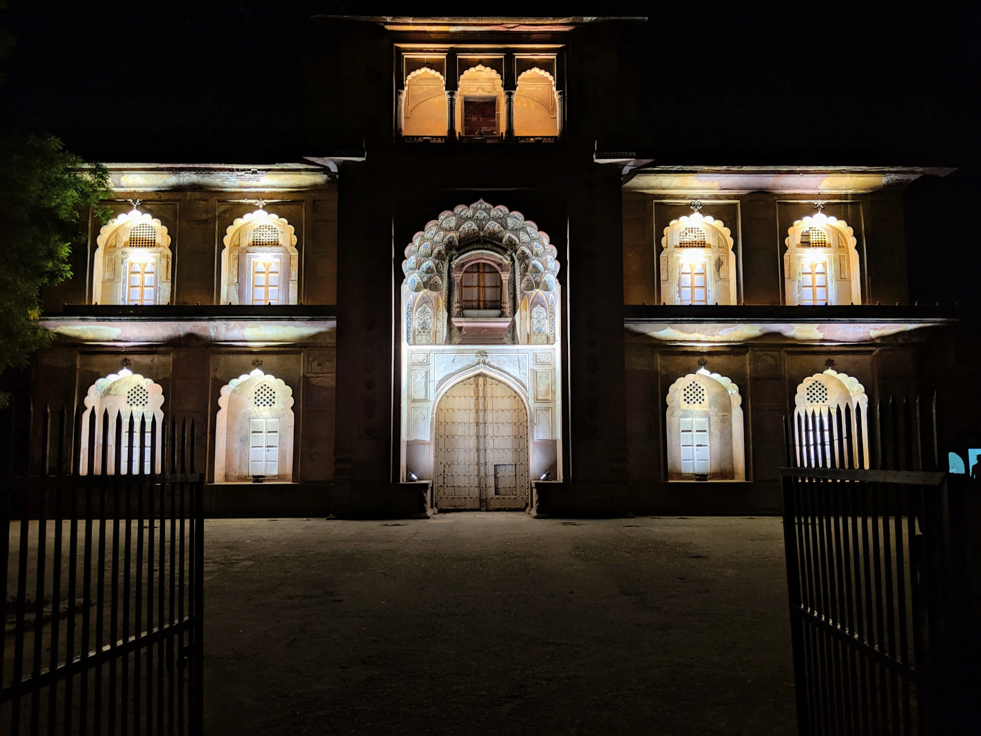 Villa facade at night with warm illuminated windows, photograph by Anahita on Unsplash