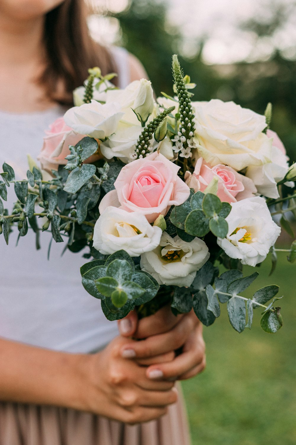 Femme tenant un bouquet de roses blanches et roses