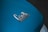 A close-up view of a car's surface displaying the badge with the words 'Corvette Sting Ray' in chrome. The surface is painted in a blue color, with a glossy finish.