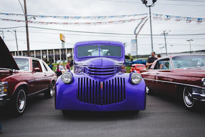 A panoramic shot of the car show with colorful banners fluttering overhead.