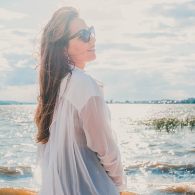 woman in white dress shirt front of sea