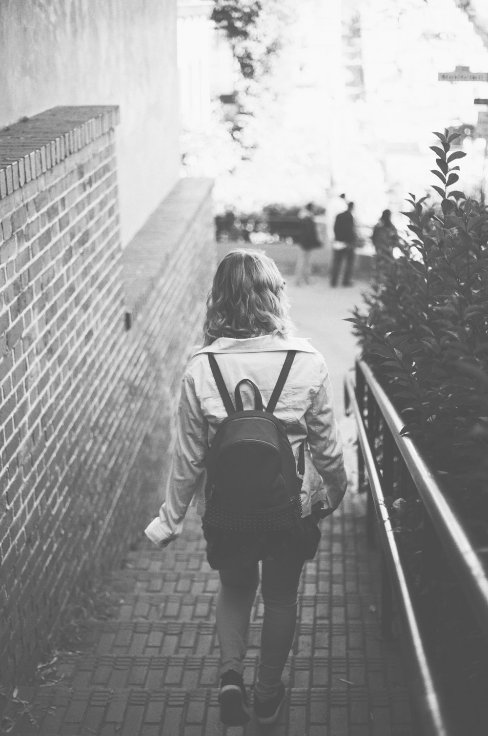 grayscale photography of woman with backpack