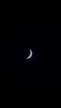 Golden crescent moon glowing softly against a deep night blue sky with subtle stars.