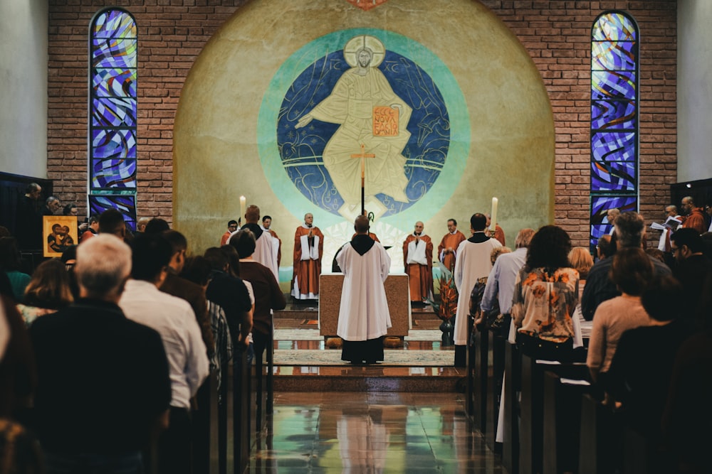 priest beside people in church