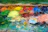 A vibrant palette with fresh paint blobs and brushes resting on a canvas.