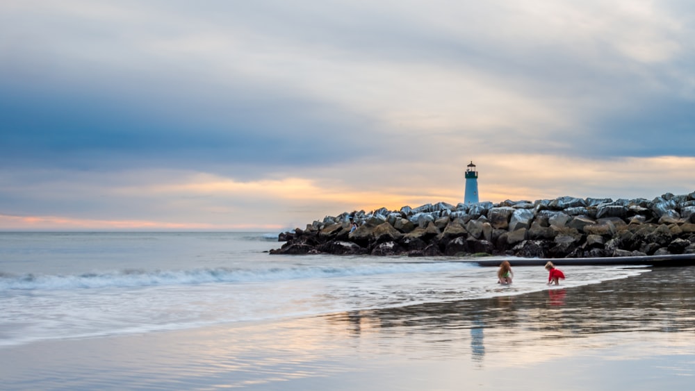 blue lighthouse near body of water during daytime