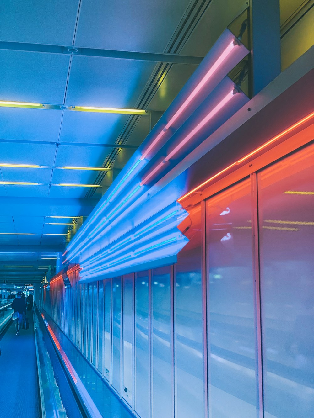 a long hallway with a blue and red light at the end of it
