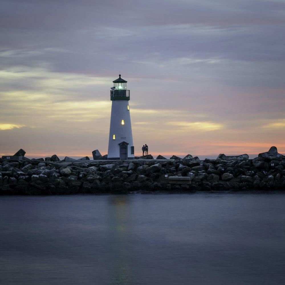 white lighthouse near body of water during daytime