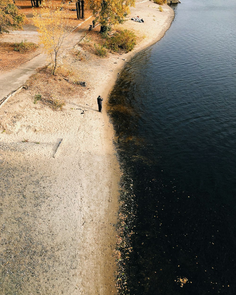 a person standing on a beach next to a body of water