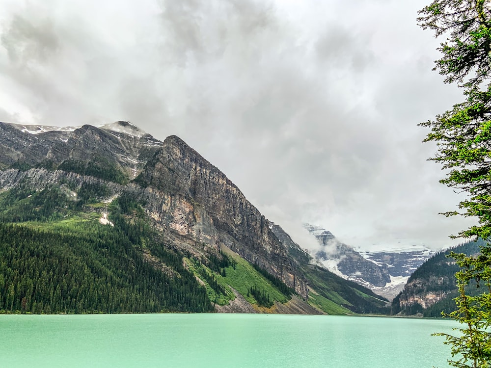 lake surrounded by mountain during aytime