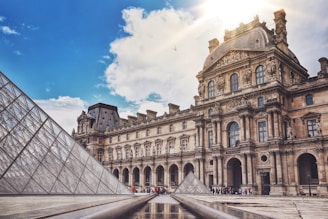The Louvre Museum and its pyramid under a blue sky for a guided tour of the museum in Paris.