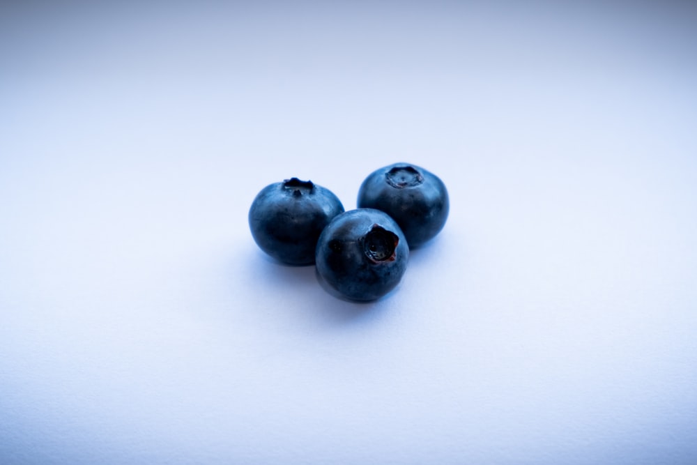 three blackberries on white surface