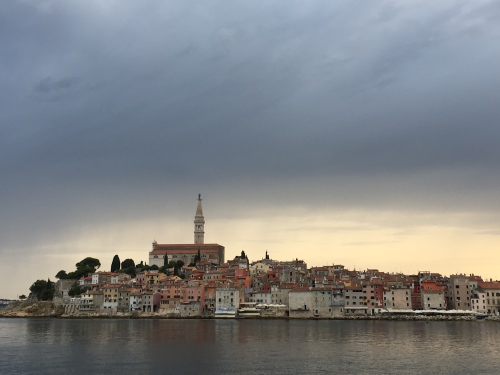 buildings near body of water under cloudy sky