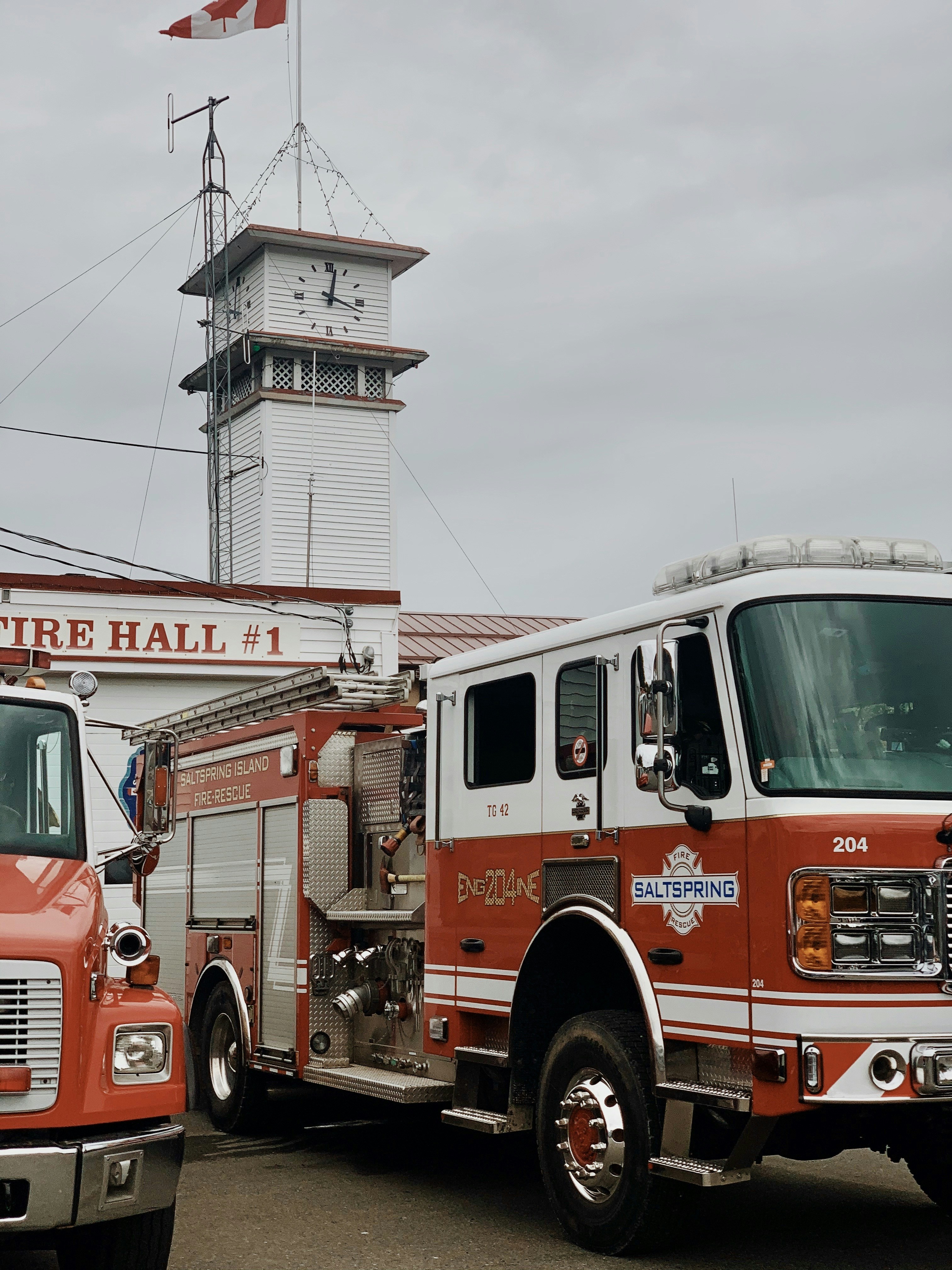 white and red firetruck near clock tower during daytime