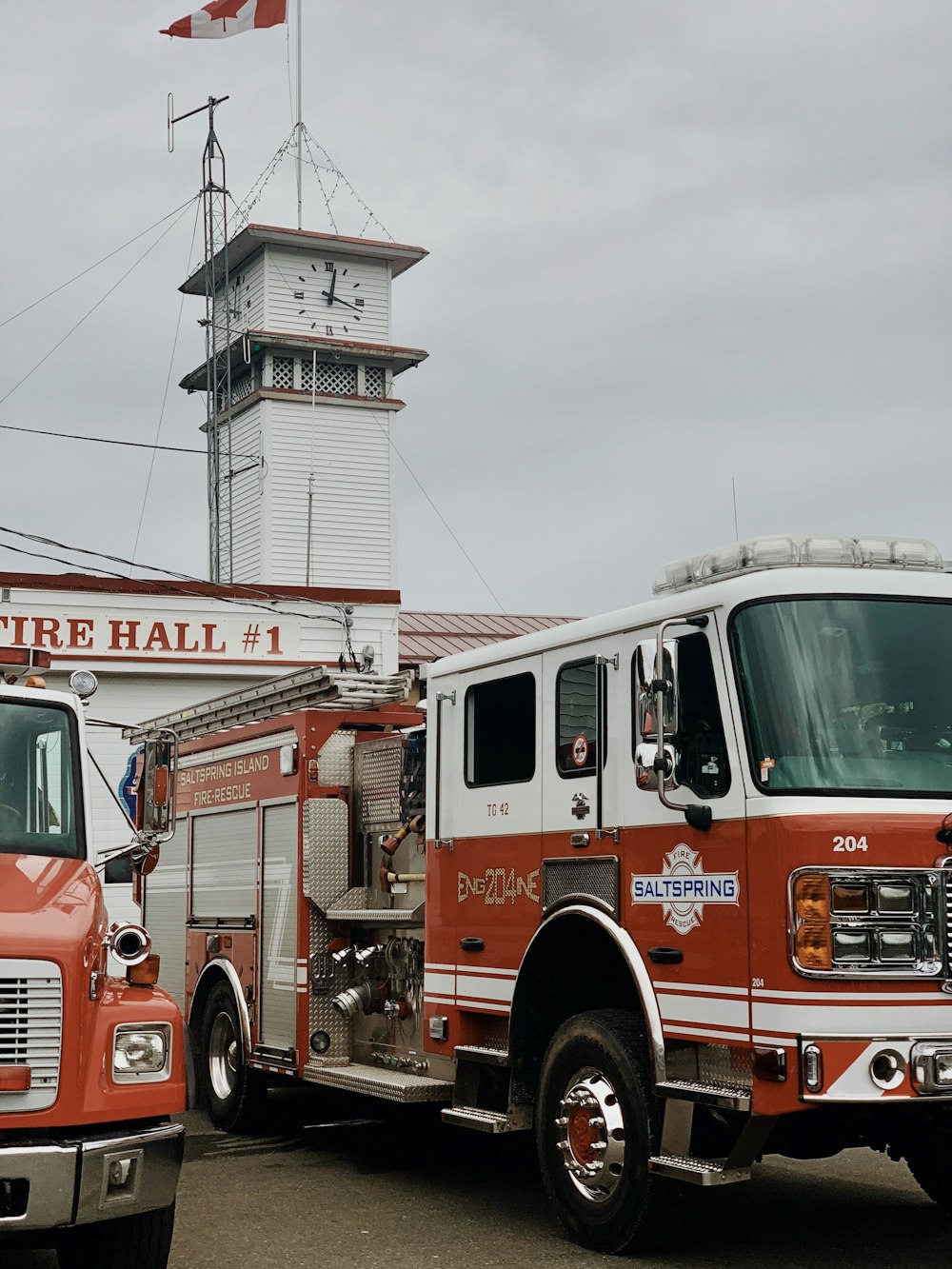 white and red firetruck near clock tower during daytime