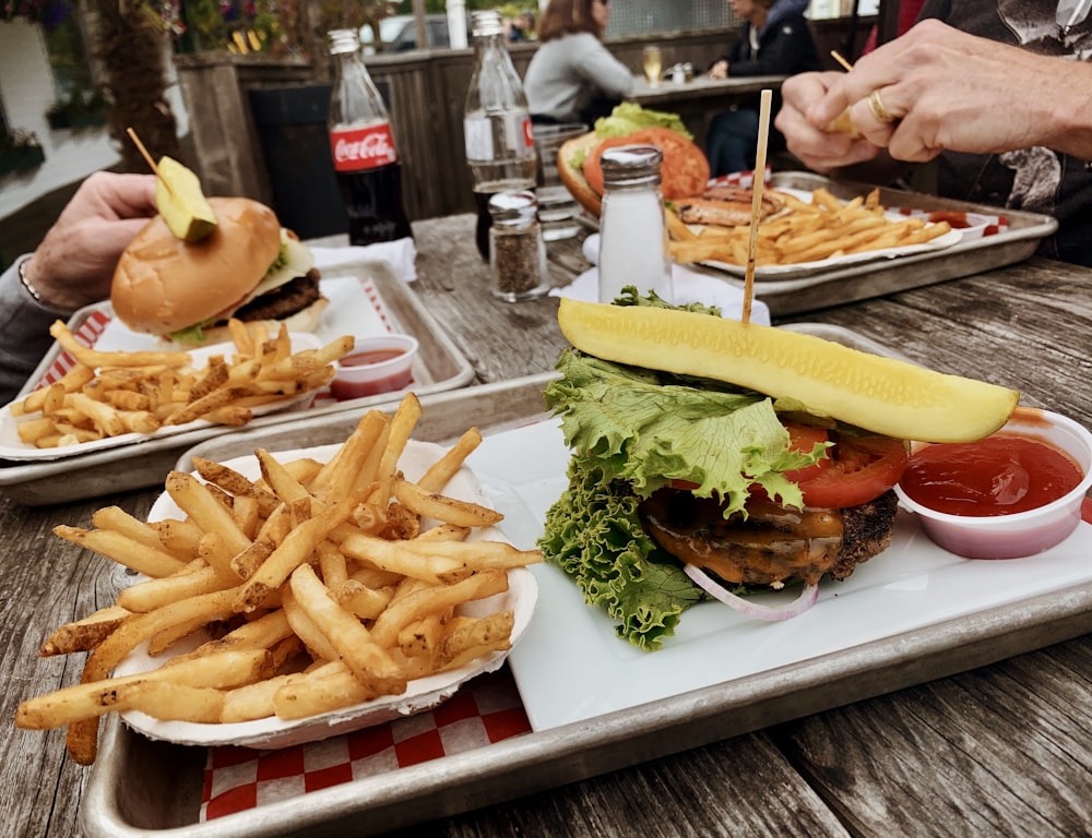 ハンバーガーの近くのポテトフライとケチャップの横のキャベツ