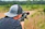 Close-up of a young boy concentrating as he takes aim with an air rifle, supervised by a friendly expert.