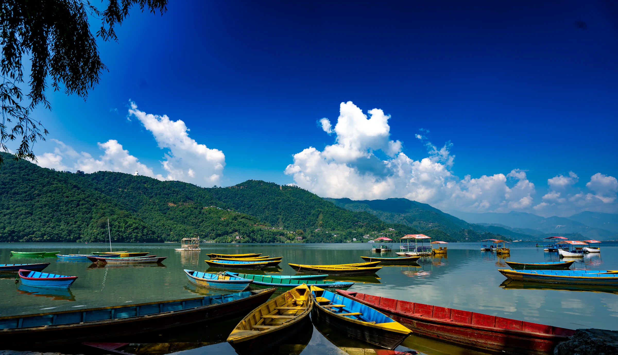 Wooden boats on Phewa Lake, Pokhara, with the Annapurna range behind