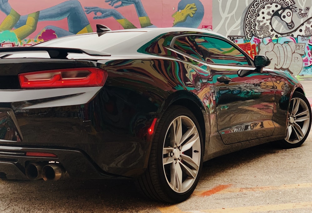 black Chevrolet Camaro coupe near painted wall