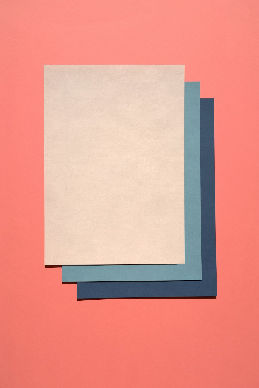 três pedaços de papel em um fundo rosa
