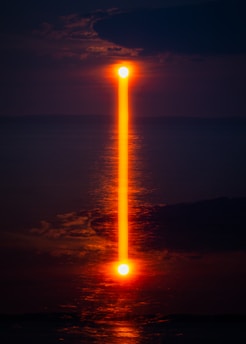 orange reflection of light on sea from moon at night time