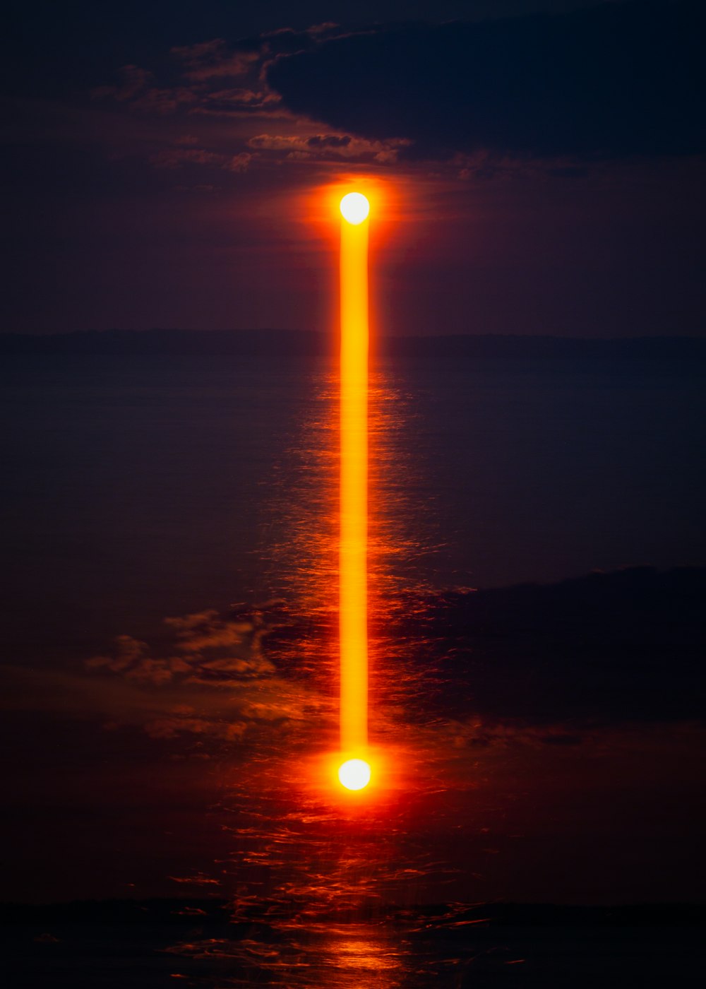 Riflesso arancione della luce sul mare dalla luna di notte