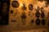 A panel featuring multiple round gauges with letters 'V' and 'A', possibly indicating voltage and amperage. The panel is constructed of metal with various switches, dials, and labels in an industrial setting. Light from an overhead lamp casts a warm glow over the entire setup.