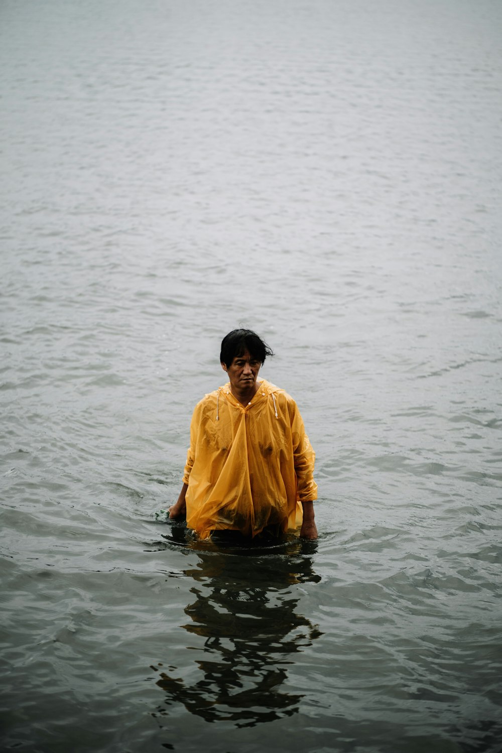 person wearing orange button-up jacket on body of water during daytime