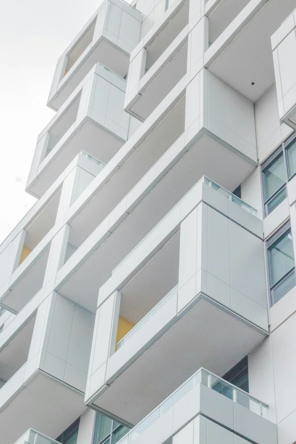 low-angle photography of white concrete multi-storey building