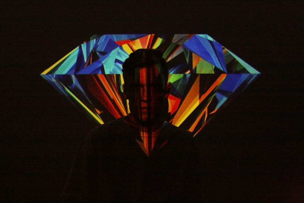 man standing in front of projection of diamond