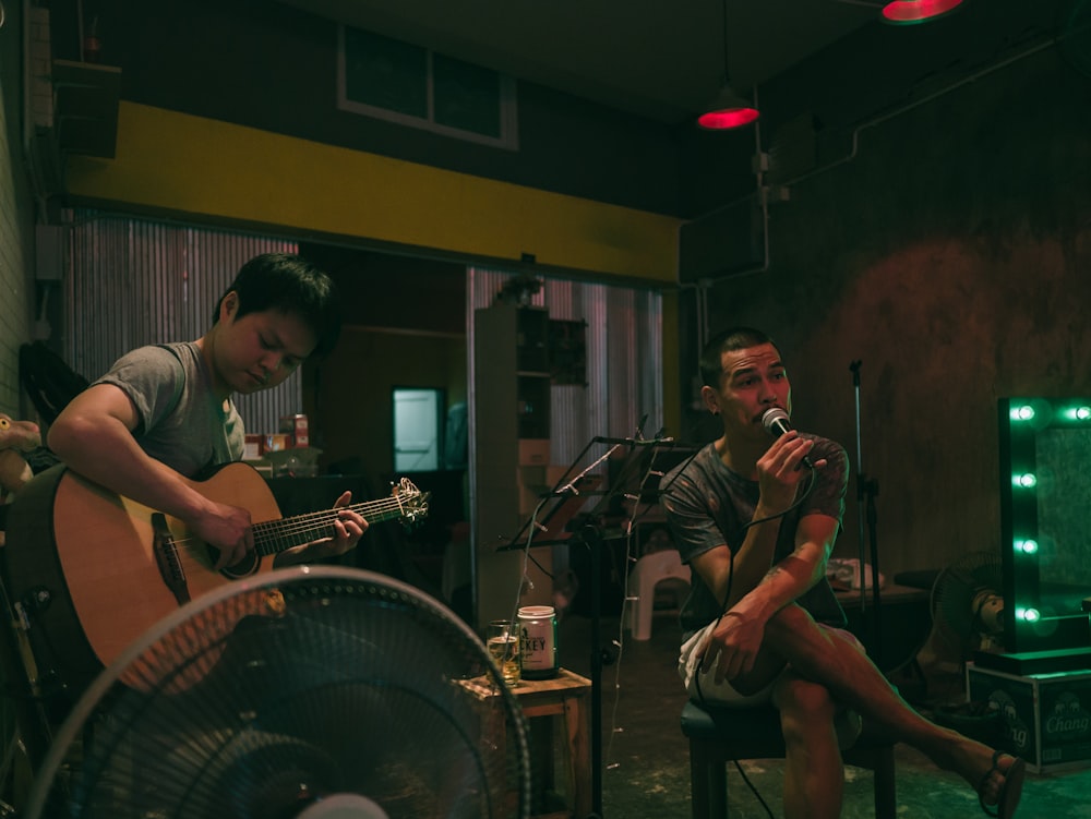 man singing beside man playing guitar